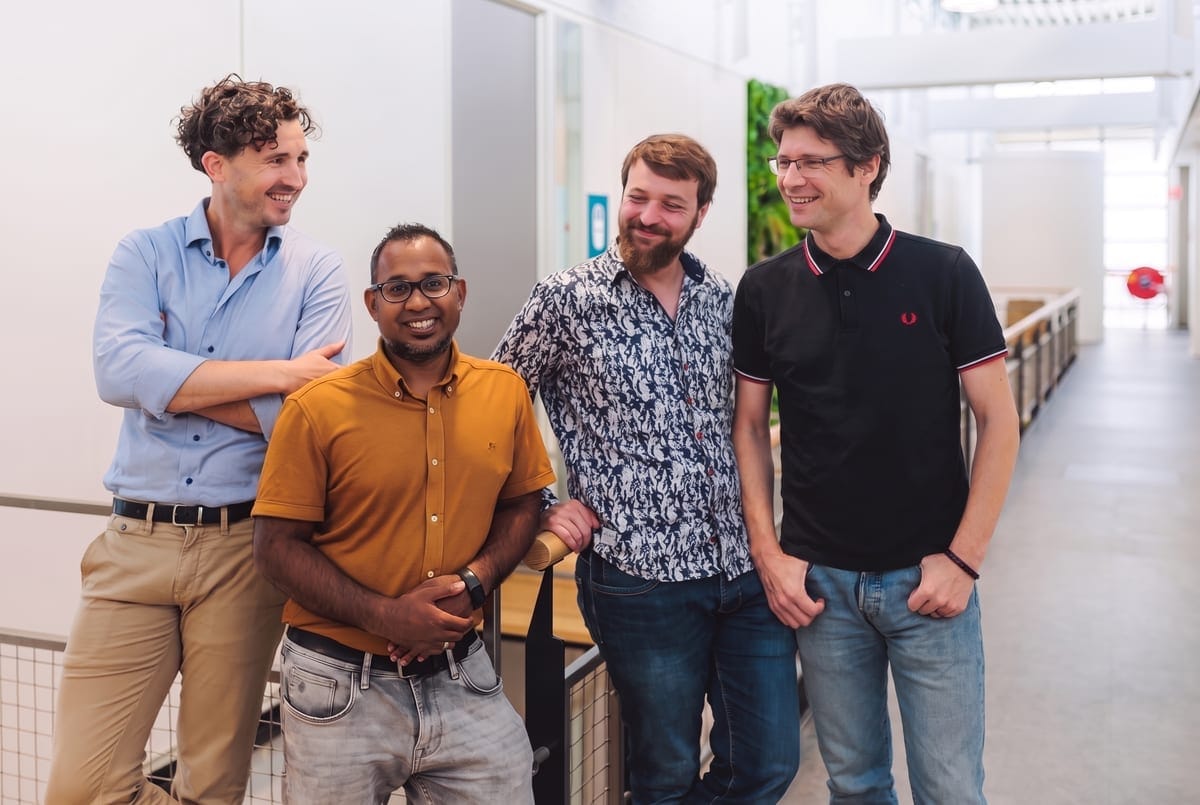 Het And AI team: vier collega's lachend bij elkaar in een lichte kantoorgang